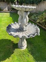 Full view of two-tier concrete bird bath on lawn
