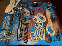 Full lot overview showing variety of necklaces, bracelets, earrings, brooches and pliers