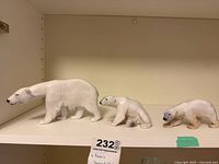 three porcelain polar bear figurines on shelf