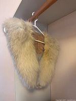 Front view of cream fox fur stole on hanger