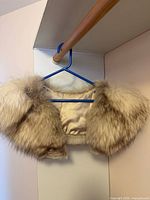 Full view of fox fur stole on hanger showing overall shape