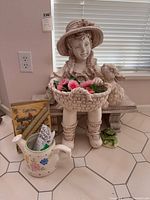 Full view of resin girl statue, ceramic sprinkler, boxed candles, frog figurine