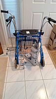 Front view of Walker Works rollator, quad cane, walking boot and small aids