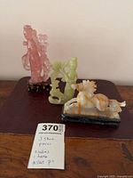 Group shot of three stone figurines with measurement note