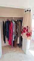 Full closet view showing multiple garments and hanging floral skirt