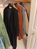 Closet view showing multiple colored coats on hangers