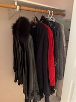 Five garments hanging on rail showing variety of outerwear pieces