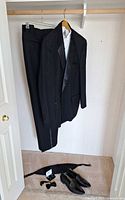 Entire tuxedo ensemble hanging with accessories on floor