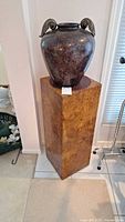 Burl veneer pedestal with ceramic vase on top, full view