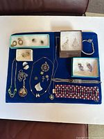Overview of all jewelry items laid out on blue board