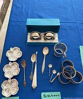 Group shot showing Lenox dishes, sterling napkin rings, spoons, picks and cup holder