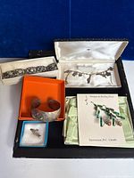 All five jewellery pieces in their individual boxes and cases.