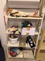 Full shelving unit with assorted tools, bulbs, hardware