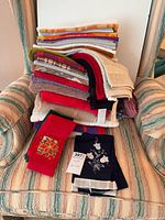 overall stack of towels on chair with embroidered pieces in front