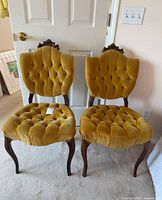 Front view of both mustard velvet tufted chairs