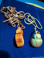 Both necklaces side by side on blue surface