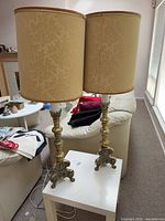 Full view of both brass lamps with shades on table