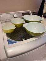 All four Pyrex green Cinderella bowls nested together on washing machine