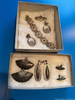 All seven jewelry pieces arranged in two boxes showing overall lot