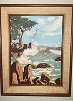 Framed oil seascape painting showing coastal scene, signature visible lower left