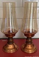 Front view showing both copper hurricane lamps with glass chimneys