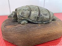 Side view of soapstone turtle on wooden base