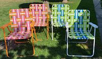 Group shot of all four colourful folding lawn chairs on grass