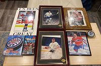 Overview of all framed photos, board game, publication and puck laid out on table