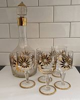 Front view decanter and five glasses showing gold sunflower motif