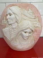 Full view of ceramic vase front showing embossed Indigenous couple and pine trees