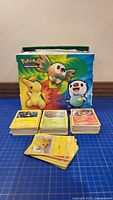 Front view showing several stacks of Pokémon cards and the themed storage box