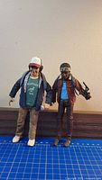 Front view of both action figures standing side by side