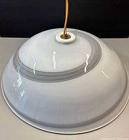 Exterior top view of white glass dome shade with grey rings and cord