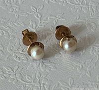 Front view of both pearl stud earrings showing pearls and gold cups
