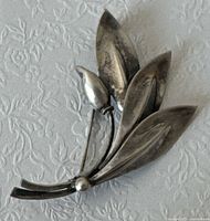 Front view of brooch showing leaf and bud design