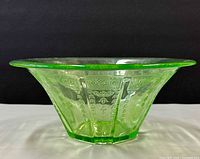 Side profile of green depression glass bowl showing flared shape and embossed panels