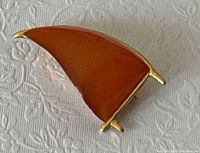 Front view showing curved triangular amber cabochon and gold-tone frame