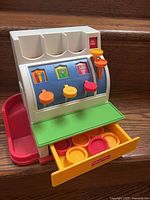 Front view of cash register with drawer open showing coins