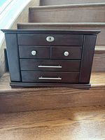 front view of closed jewelry box showing drawers and hardware