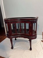 Full view of kidney-shaped glass display cabinet on cabriole legs
