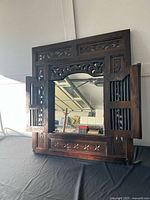 Mirror with doors open showing carved frame and glass