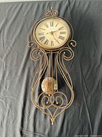 Full view of bronze metal Sterling & Noble pendulum wall clock