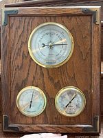 Full view of oak plaque showing all three instruments and corner brackets