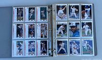 Binder open showing two sleeve pages of Blue Jays cards, both card fronts and stats visible