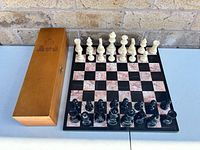 board with pieces set up and storage box