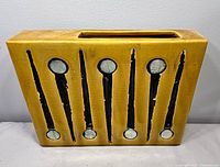 Front view showing mustard glaze and atomic motif