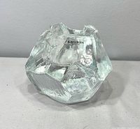 Front view showing Kosta Boda label and faceted shape