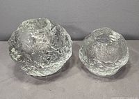 Front view of both Kosta Boda Snowball holders large left small right