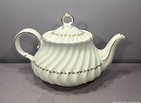 Left side view of Royal Doulton Adrian teapot showing ribbed body and gold trim