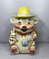 Front view of Treasure Craft farmer pig cookie jar with lid on